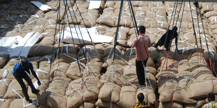 Three men stacking burlap sacks